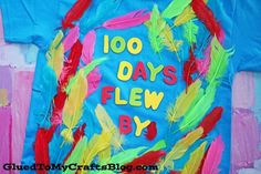 a t - shirt that says 100 days flew by with colorful feathers on the front