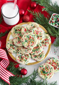 christmas sprinkle cookies on a plate next to a glass of milk and candy canes