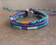 three bracelets with different colored beads on a table