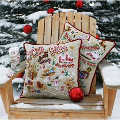 a wooden chair sitting in front of a christmas tree with two pillows on top of it