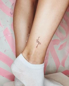 a woman's foot with a small tattoo on her left ankle and the word love is written in cursive writing