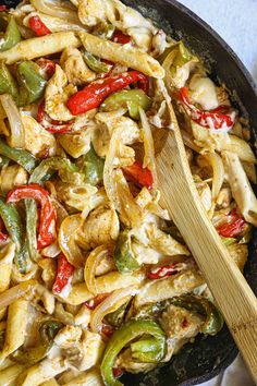 a skillet filled with chicken, peppers and noodles