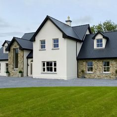 a large white house with black roof and windows