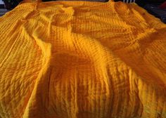 a yellow bedspread on top of a bed in a room