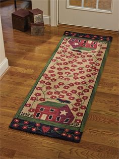 a long rug on the floor in front of a door with flowers and a house painted on it