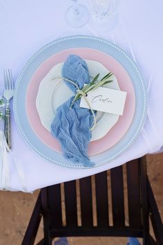 a place setting with blue napkins and white plates