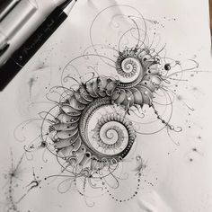 an artistic drawing with spirals and dots on white paper next to a marker pen