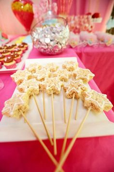 some food is sitting on top of a white plate and pink table cloth with other items in the background