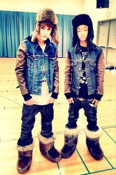 two young men standing next to each other on a basketball court wearing boots and jackets