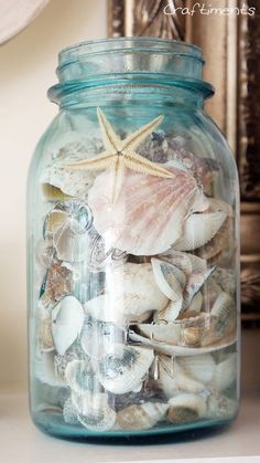 a glass jar filled with sea shells and starfish