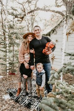 a man and two children standing in front of a christmas tree