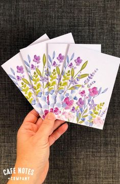 hand holding five cards with watercolor flowers on them