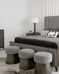 a modern bedroom with stools and a bed