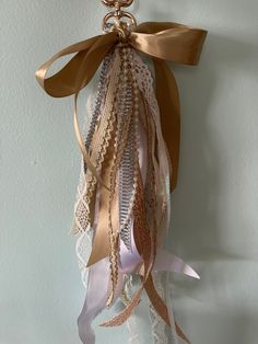 a gold and white ribbon hanging from the side of a wall with ribbons attached to it