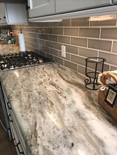 a marble kitchen counter top next to an oven