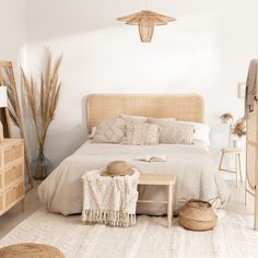 a bedroom with white walls and beige bedding is pictured in this image, there are two wicker baskets on the nightstands next to the bed