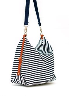 "The Marina diaper bag has been designed for your everyday life, able to carry anything you may need during your daily activities The bag is made from a cotton canvas, in a nice navy blue and white striped pattern and has leather details at the sides, which provides a very nice shape. It closes with a zipper and it is fully lined with a cotton canvas, with the color of your choice (yellow or light grey). This Marina diaper bag has one strap, made from a thick cotton twill in navy blue color, whi Everyday Striped Bags With Leather Handles, Travel Bags With Striped Cotton Design, Travel Bags With Striped Cotton Material, Striped Cotton Travel Bags, Striped Cotton Shoulder Bag For Daily Use, Striped Canvas Shoulder Bag For Daily Use, Everyday Striped Canvas Bag, Everyday Striped Bag With Adjustable Strap, Striped Bag With Adjustable Strap For Everyday Use