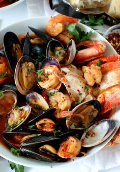 a white bowl filled with seafood and mussels