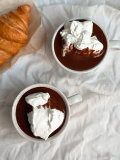 two cups filled with hot chocolate and whipped cream