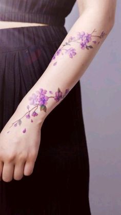 a woman's arm with purple flowers on it