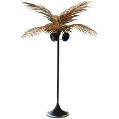 a tall metal palm tree with two balls on it's top and one branch