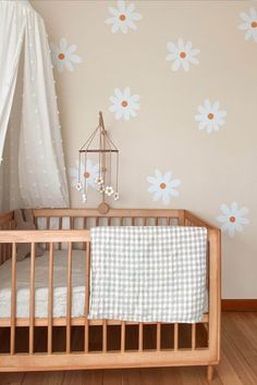 a baby crib in front of a wall with flowers on it