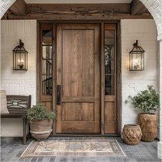 a wooden door with two planters on either side and an entryway to the home