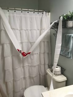 a bathroom with a shower curtain that has been pulled over and tied to the wall