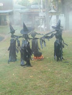 some witches are standing in the grass with their heads covered by black cloths and hats