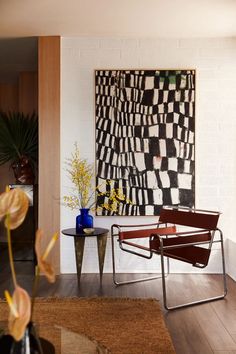 a chair and table in a room with a painting on the wall