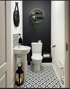 a white toilet sitting next to a sink in a bathroom under a clock on the wall