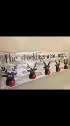 a wooden sign that says, the stockings were hung up with three reindeer heads on it