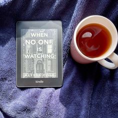 a cup of tea next to a book on a purple blanket with the title when no one is watching