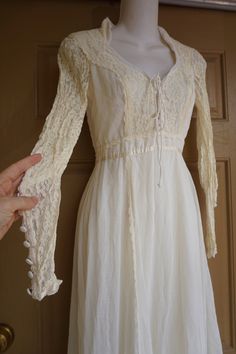 "Size 7 Gunne Sax prairie dress fits smaller - please see measurements. Zips in the back with adjustable tie at the back of the waist. In very good condition!. Measurements taken across front lying flat 15\" across front armpit to armpit 12.5\" across front of waist (ties tighter) 55\" length" Fitted Cream Victorian Dress With Long Sleeves, Beige Long Sleeve Maxi Dress With Lace Trim, Fitted Bohemian Dress With Lace-up Back, Bohemian Fitted Dress With Lace-up Back, Fitted Long Sleeve Cream Vintage Dress, Cream Fitted Long Sleeve Vintage Dress, Cream Long Sleeve Prairie Dress In Cottagecore Style, Bohemian Long Sleeve Lace Maxi Dress, Cream Victorian Dress With Long Sleeves For Spring