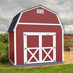 a red and white barn sitting in the grass