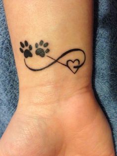 a dog paw and heart tattoo on the wrist