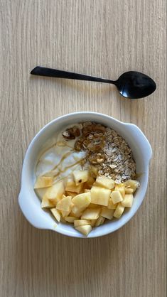 an oatmeal is in a bowl on the table next to a spoon