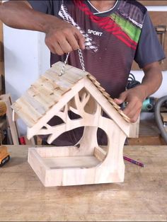 a man is making a birdhouse out of wood