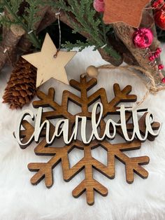 a wooden snowflake ornament with the word charlotte hanging from it's side