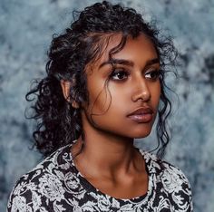 a close up of a person wearing a shirt and posing for a photo with her hair blowing in the wind