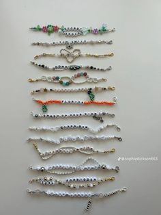 a bunch of bracelets that are hanging on a white wall with beaded beads