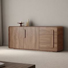 a wooden cabinet sitting in the middle of a living room next to a laptop computer