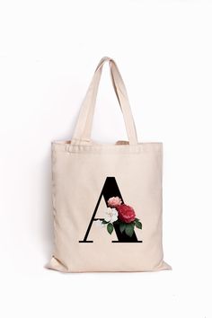 a tote bag with roses on it and the letter a in black letters is shown