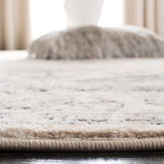 a close up of a white rug on a wooden floor