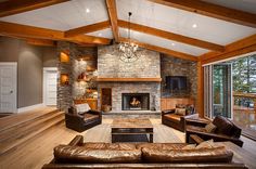 a living room filled with furniture and a fire place in the middle of a wooden floor