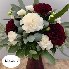 a vase filled with white and red flowers