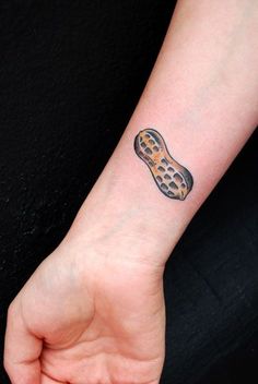 a person's hand with a tattoo on their left wrist that has a peanut butter sandwich on it