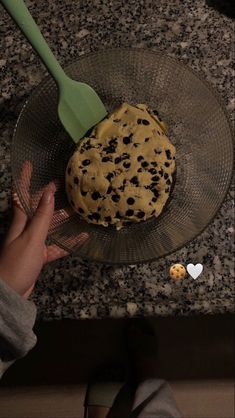 a cookie sitting on top of a glass plate next to a spatula and spoon