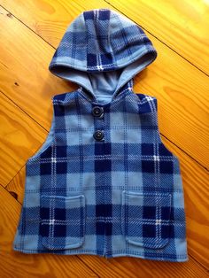 Toddler fleece vest in blue plaid, lined with warm cotton flannel. Button closure with loops and pockets. All fabric is pre-washed and put through a dryer for less shrinkage. Please refer to size chart as the vest is made to wear over a sweater. Please custom order if your child needs a different size. 🎁 Giftwrap option available! Winter Blue Flannel Outerwear, Blue Sleeveless Outerwear With Buttons, Blue Cotton Vest With Buttons, Blue Cotton Vest For Fall, Plaid Cotton Vest For Fall, Fall Plaid Cotton Vest, Boys Tops, Fleece Vest, Cotton Flannel