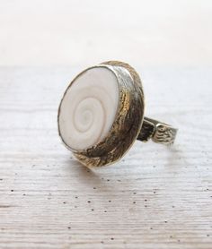 The sea has so much to give!  This fabulously organic looking ring is entirely made of sterling silver (925 and 950) and has one very pretty eye of Shiva shell, naturally and found on the beach. The ring is hand made and shape according to the shell in a bezel. Romantic yet modern. The ring is adjustable from size 6 till 9.5 (the ring is pictured as a size 9.5 the band will slide inwards to make it smaller), please let us know your size so that we can adjust it for you. If you don't know your ring size, please check this site: http://www.weddingbandsuperstore.com/ringsize.html More sea treasures coming up, and we will gladly make the custom order to your wishes and dreams with sea treasures! All metal is nickel and lead free. Two shipping options: Registered airmail takes 15 - 30 days on a Seashell Ring, Solitaire Rings, Pretty Eyes, Solitaire Ring, Shiva, Sea Shells, Jewelry Rings, Shells, Ring Size